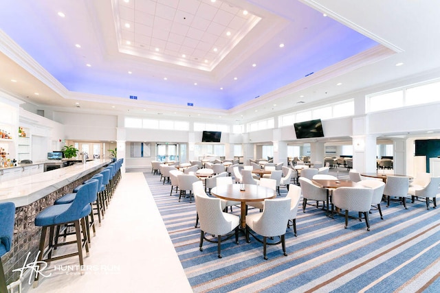 dining room featuring a high ceiling and a raised ceiling