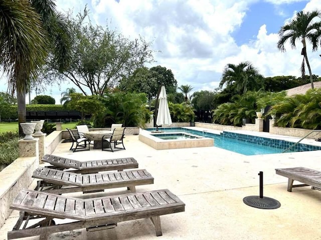 view of pool with an in ground hot tub and a patio area