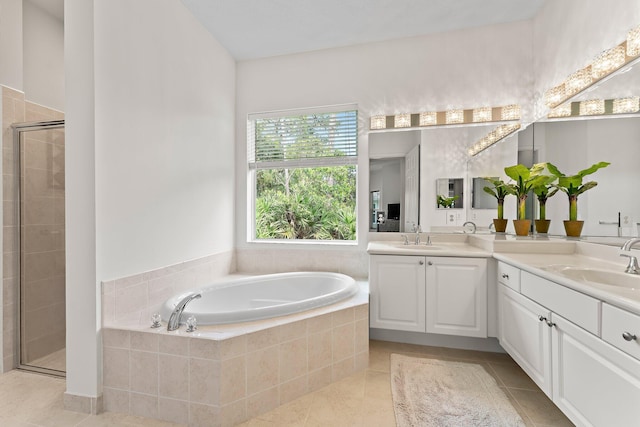 bathroom featuring a sink, double vanity, a stall shower, a bath, and tile patterned flooring