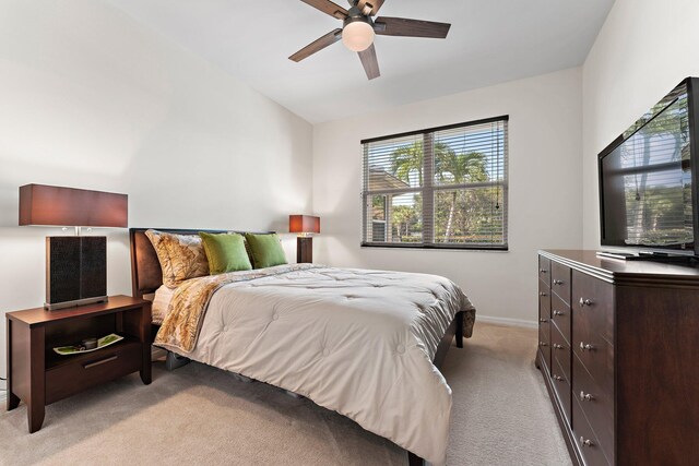 bedroom featuring a ceiling fan, vaulted ceiling, light carpet, and baseboards