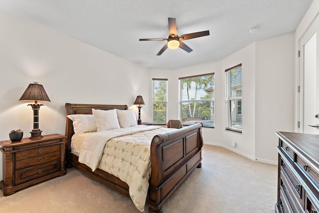 bedroom featuring baseboards, a ceiling fan, a textured ceiling, and light colored carpet