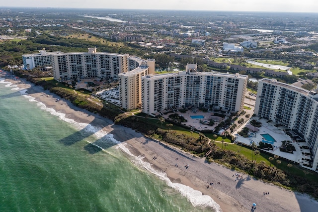 drone / aerial view featuring a water view and a beach view