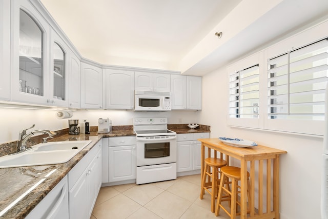 kitchen featuring white cabinets, white appliances, light tile patterned floors, and sink