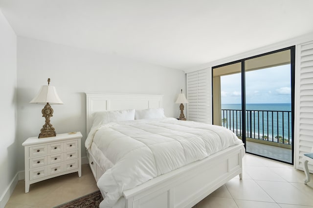 tiled bedroom featuring access to exterior, a water view, and expansive windows