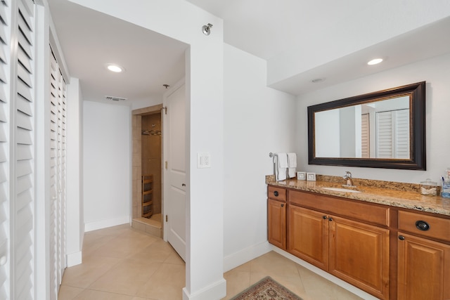 bathroom with tile patterned floors, walk in shower, and vanity