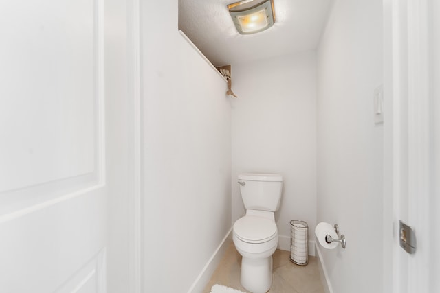 bathroom with toilet and tile patterned flooring