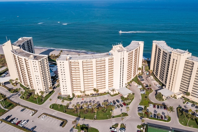 birds eye view of property featuring a water view and a beach view