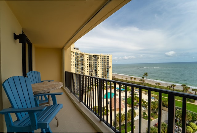 balcony featuring a water view and a view of the beach