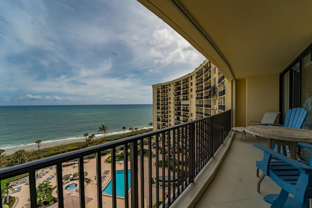 balcony featuring a beach view and a water view