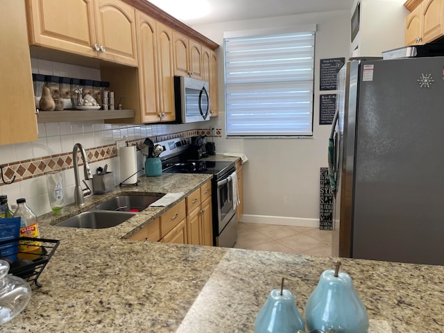 kitchen featuring backsplash, sink, light tile patterned flooring, appliances with stainless steel finishes, and light stone counters