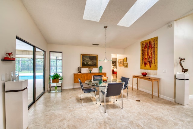 dining area with lofted ceiling with skylight and a textured ceiling