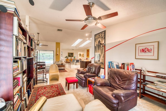 living room with light carpet, a textured ceiling, a skylight, and ceiling fan