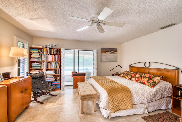 bedroom with ceiling fan and a textured ceiling