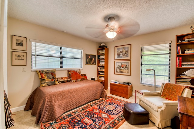 carpeted bedroom with a textured ceiling and ceiling fan