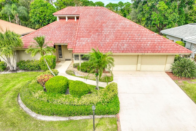 mediterranean / spanish house featuring a front lawn and a garage