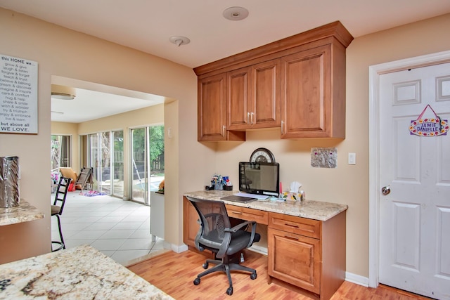 office with built in desk and light hardwood / wood-style flooring