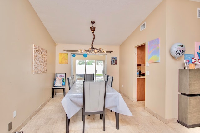 dining area with lofted ceiling and a chandelier