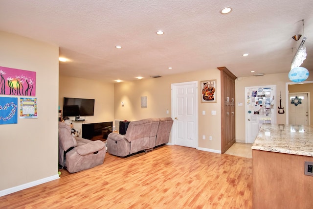 living room featuring light hardwood / wood-style flooring and a textured ceiling