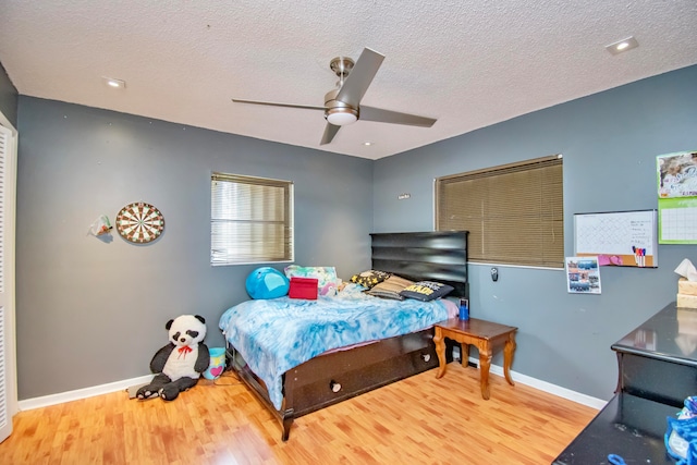 bedroom with hardwood / wood-style floors, a textured ceiling, and ceiling fan