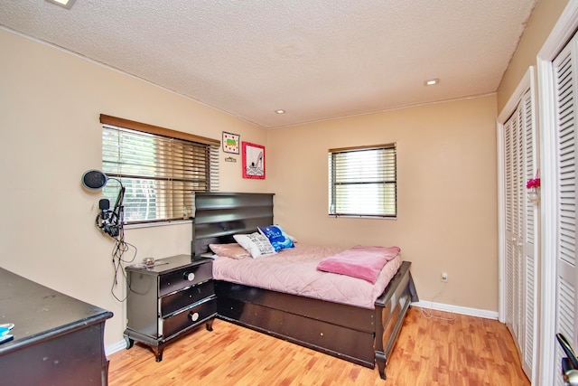 bedroom with light hardwood / wood-style floors and a textured ceiling