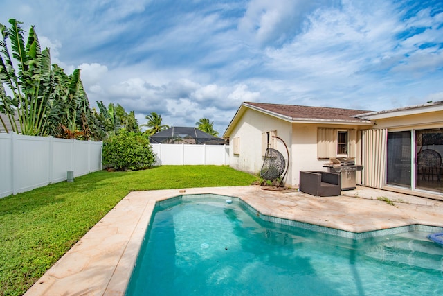 view of pool with a patio and a yard