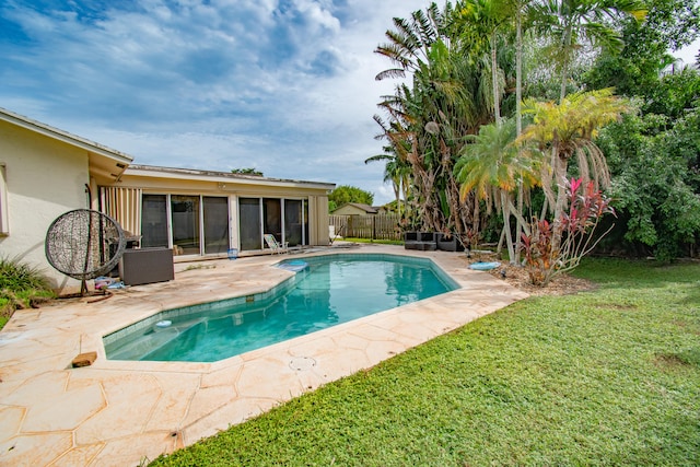 view of pool with a patio area and a yard