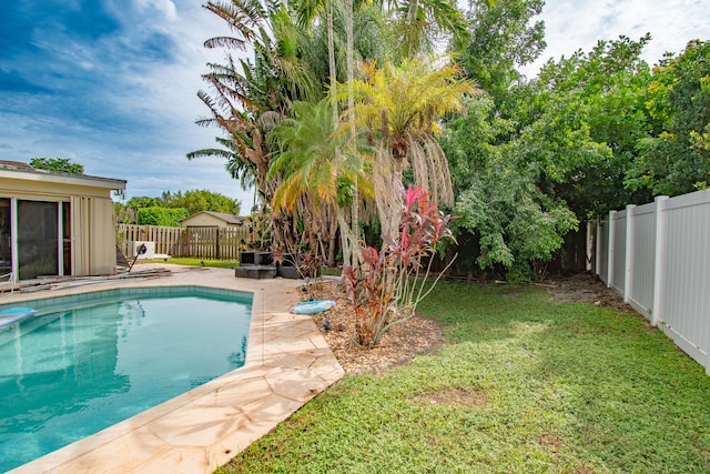 view of swimming pool with a patio and a lawn