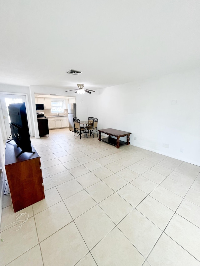 interior space featuring light tile patterned floors and ceiling fan