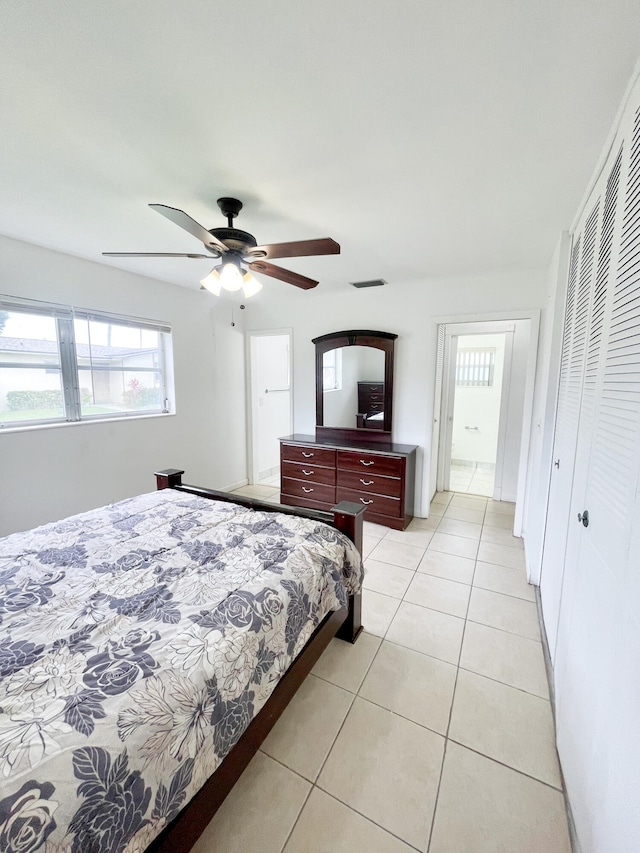 bedroom featuring ceiling fan, a closet, and light tile patterned floors