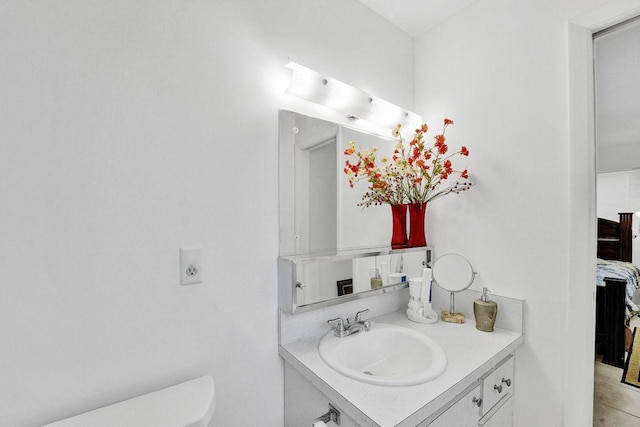 bathroom with tile patterned flooring, vanity, and toilet