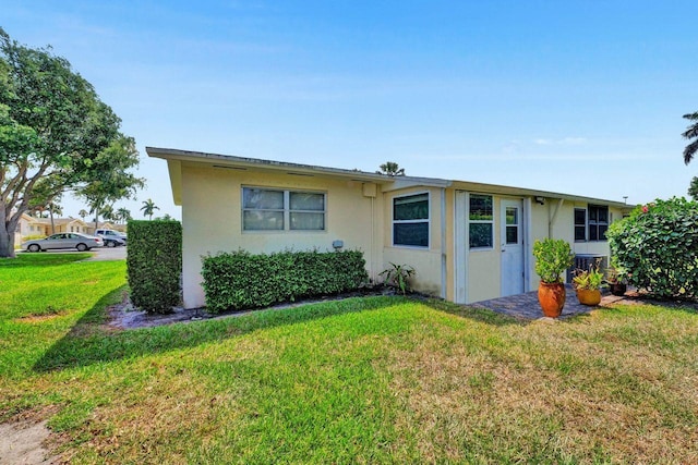 view of front of property featuring central AC unit and a front yard