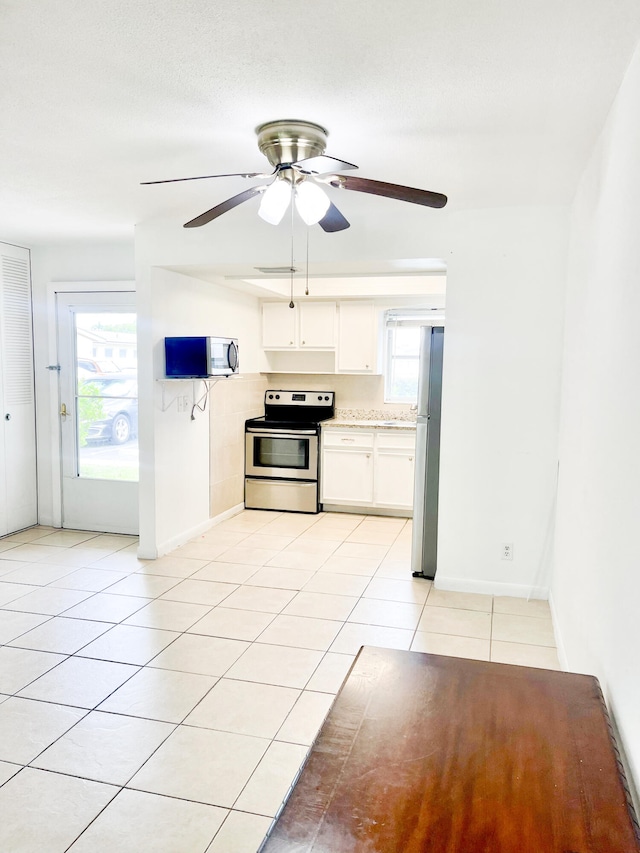 kitchen with white cabinetry, light tile patterned floors, ceiling fan, and appliances with stainless steel finishes