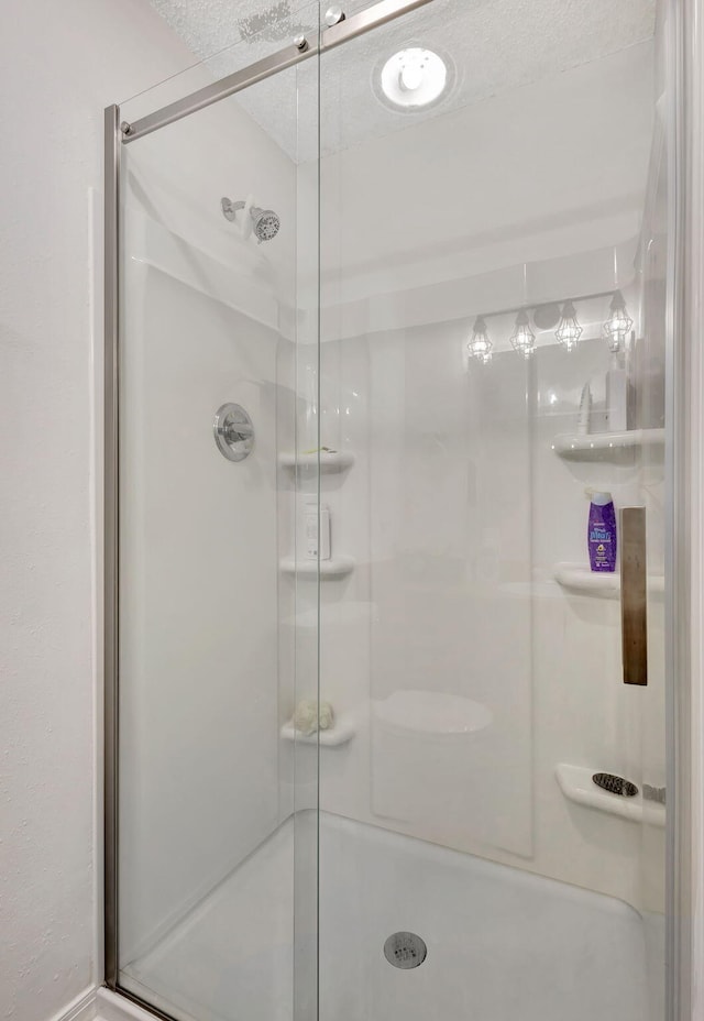 bathroom featuring a textured ceiling and walk in shower