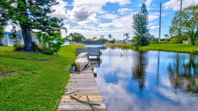 dock area with a water view and a yard