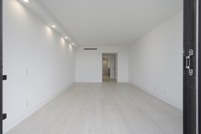 empty room featuring a wall of windows and light wood-type flooring