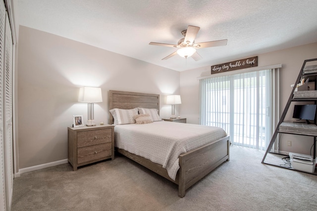 carpeted bedroom with access to outside, a textured ceiling, a closet, and ceiling fan