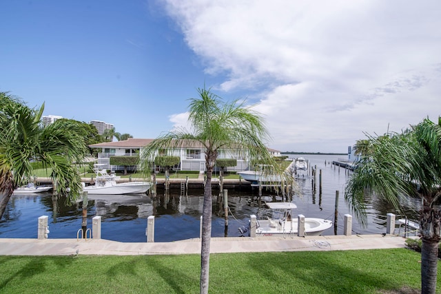 view of dock with a yard and a water view