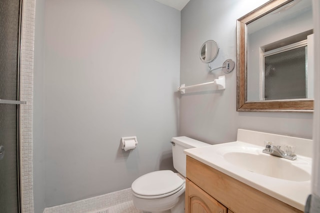 bathroom featuring tile patterned floors, vanity, toilet, and a shower with shower door