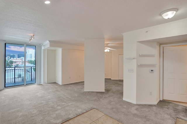 carpeted empty room with a textured ceiling and ceiling fan