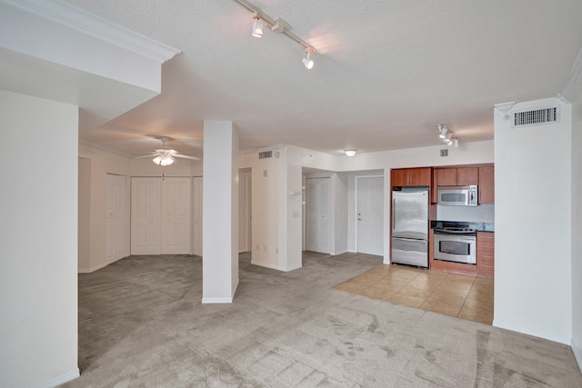 kitchen with track lighting, light carpet, ornamental molding, appliances with stainless steel finishes, and ceiling fan