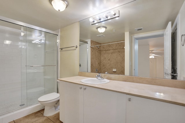 bathroom featuring tile patterned floors, toilet, vanity, an enclosed shower, and ceiling fan