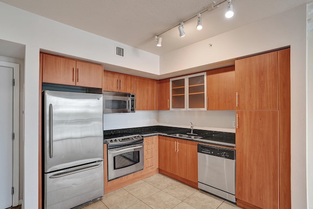 kitchen featuring light tile patterned flooring, appliances with stainless steel finishes, sink, and track lighting