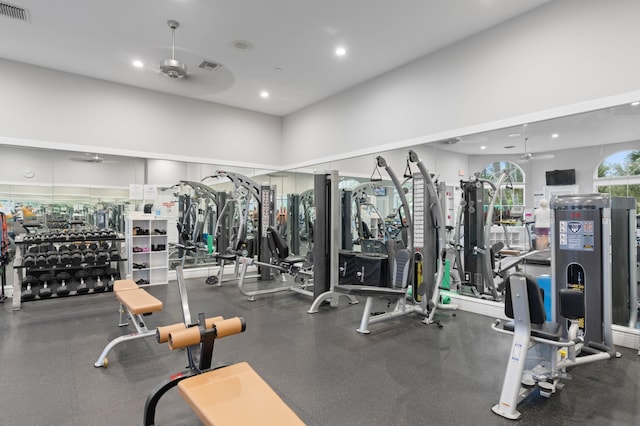 exercise room with a towering ceiling and ceiling fan