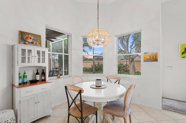 dining area with a high ceiling, a wealth of natural light, a notable chandelier, and light tile patterned flooring