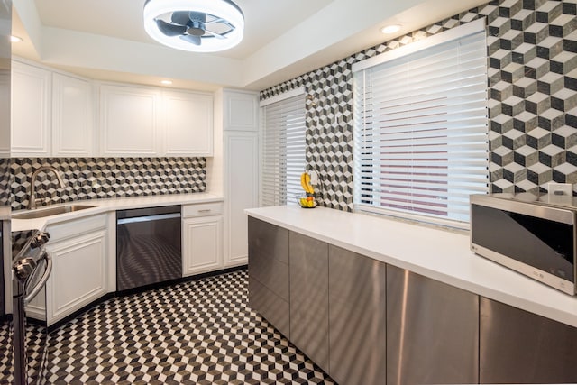 kitchen with appliances with stainless steel finishes, sink, and white cabinets