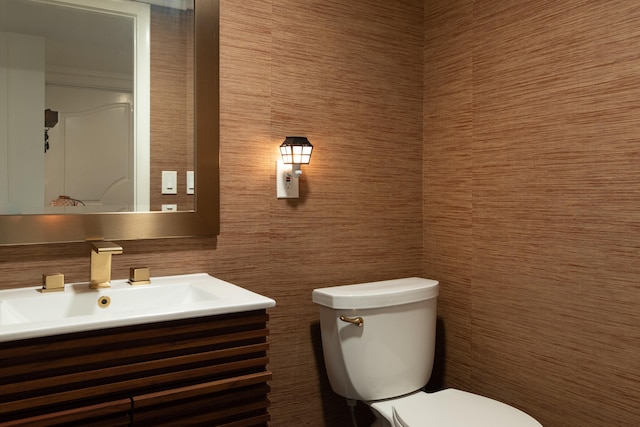 bathroom featuring vanity, toilet, and tile walls