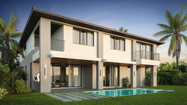 rear view of property featuring a yard and a balcony