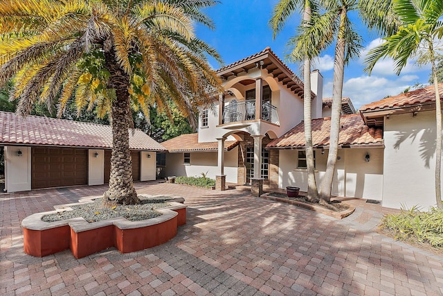 mediterranean / spanish-style home with a balcony and a garage