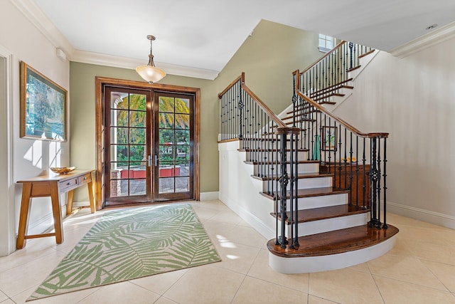 tiled entryway with ornamental molding and french doors