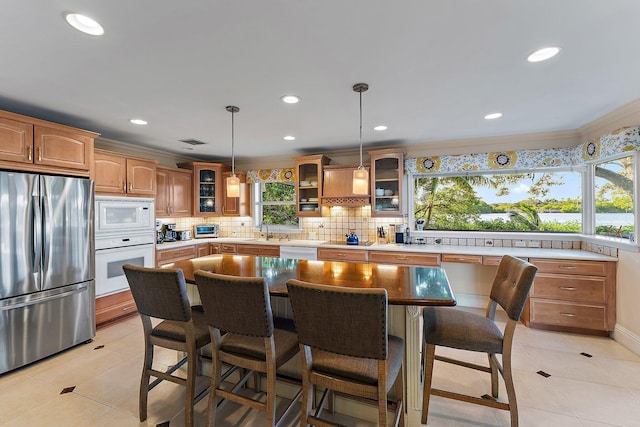 kitchen featuring a kitchen island, plenty of natural light, decorative light fixtures, and appliances with stainless steel finishes